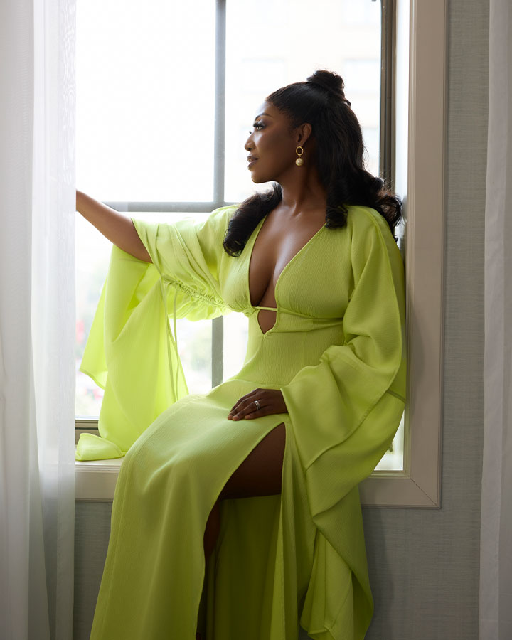 woman posing on a window sill in lime green dress