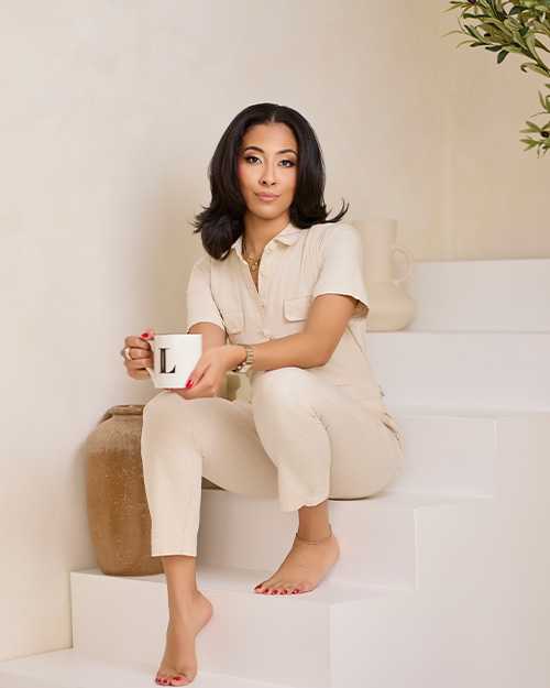 a woman posing on stairs with a mug