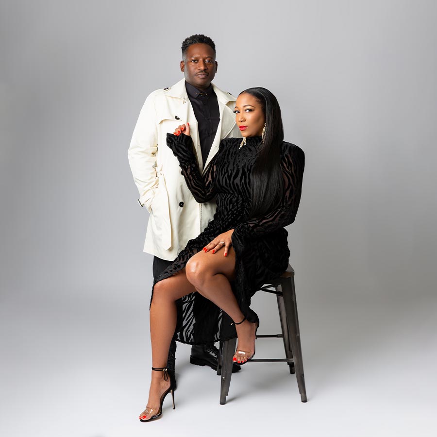 Black couple posing on a stool