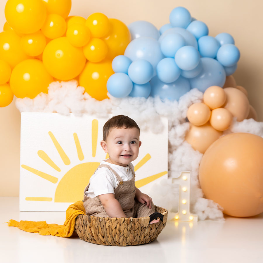 one year old boy with sun prop and balloons photoshoot