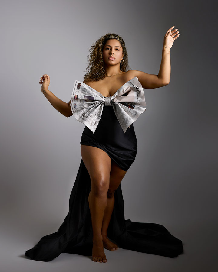 Black and Mexican woman standing in editorial pose with giant bow