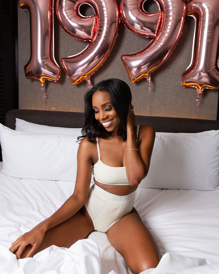 woman posing for birthday shoot with balloons in background