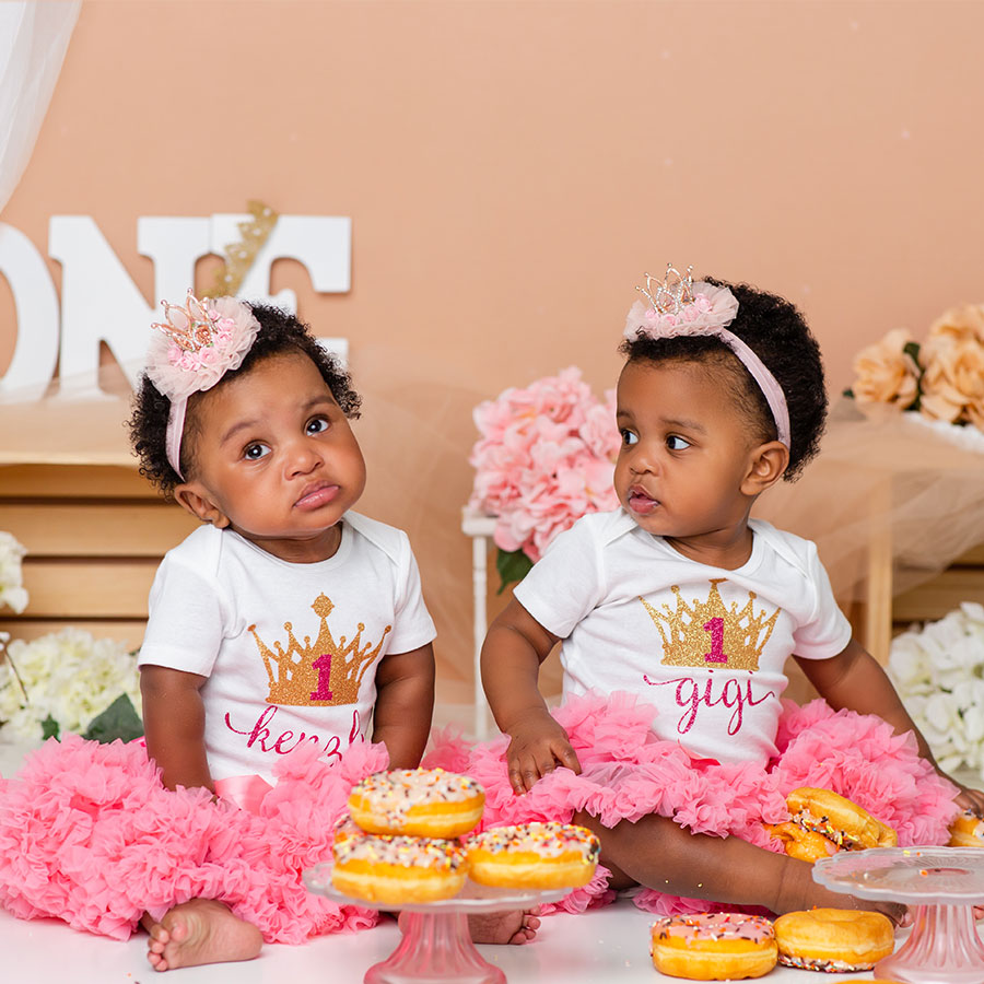 twins one year olds eating donuts for birthday photoshoot